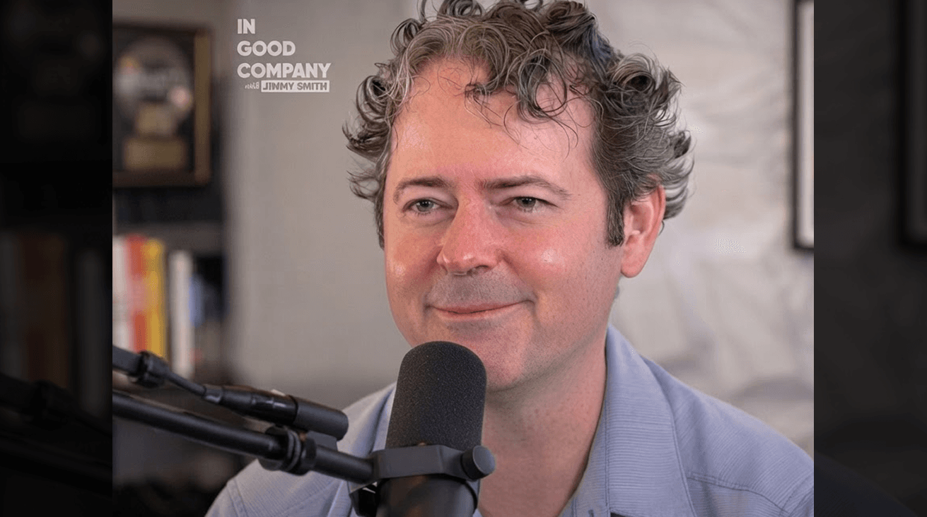 JK McKnight seated behind a podcast microphone on In Good Company with Jimmy Smith, with the show's logo in the top-left corner.