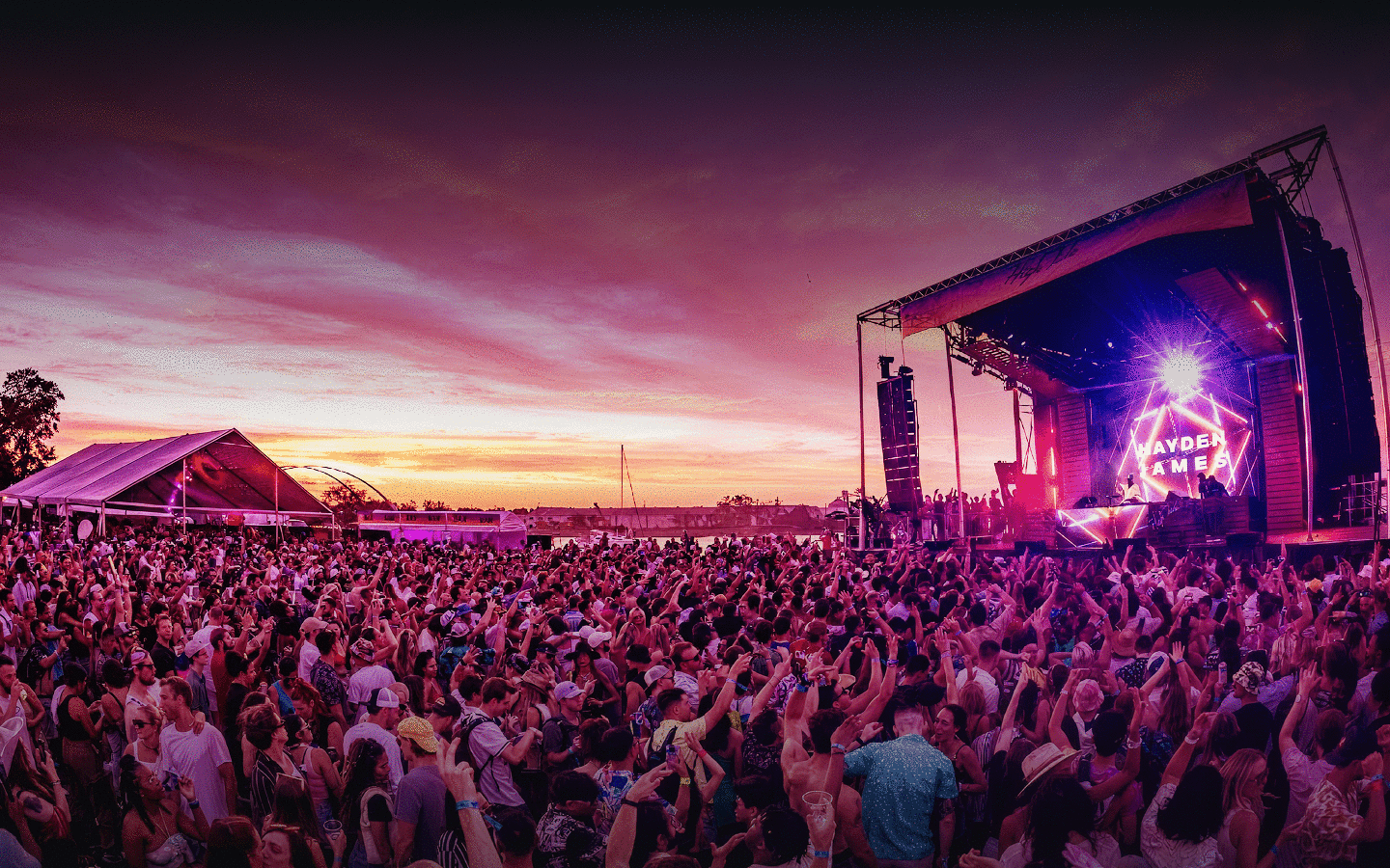 Festival crowd at sunset in front of the Hayden James main stage