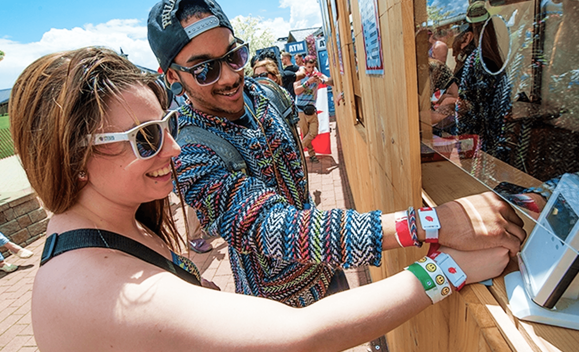 Festival-goers tapping RFID wristbands to check in at a booth
