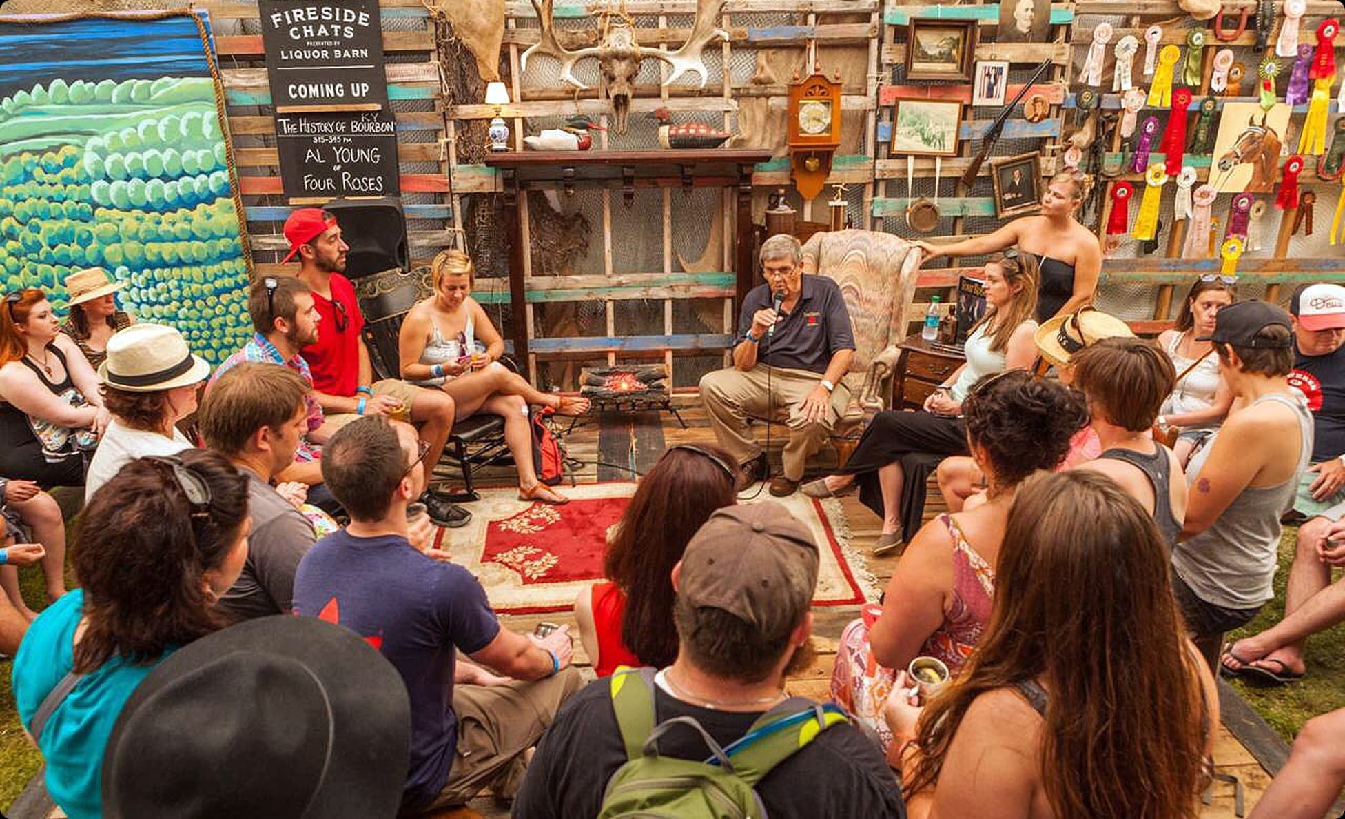Intimate fireside chat with a crowd seated in a rustic cabin setting