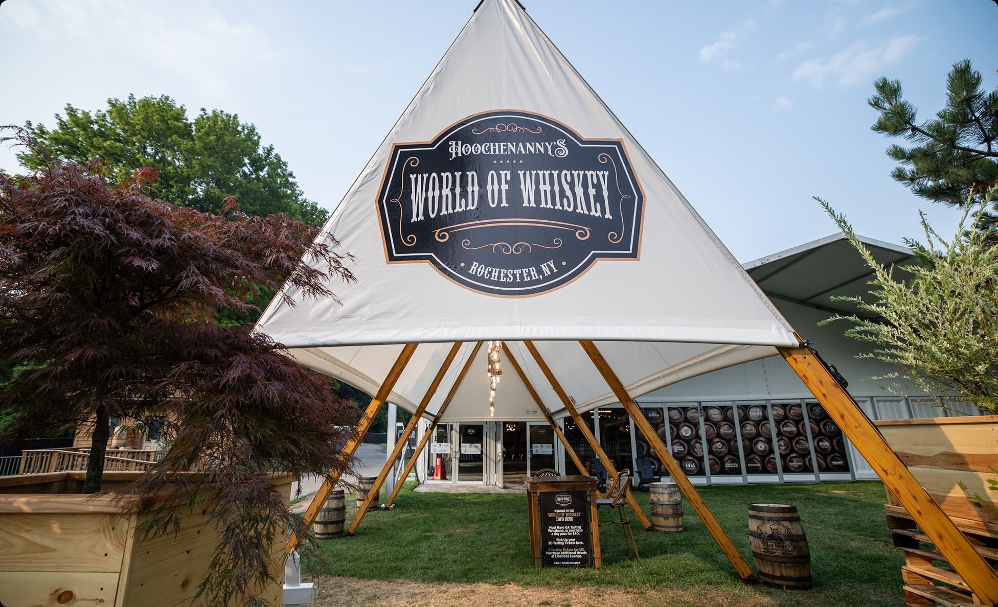 Peaked tent entrance branded World of Whiskey with bourbon barrels