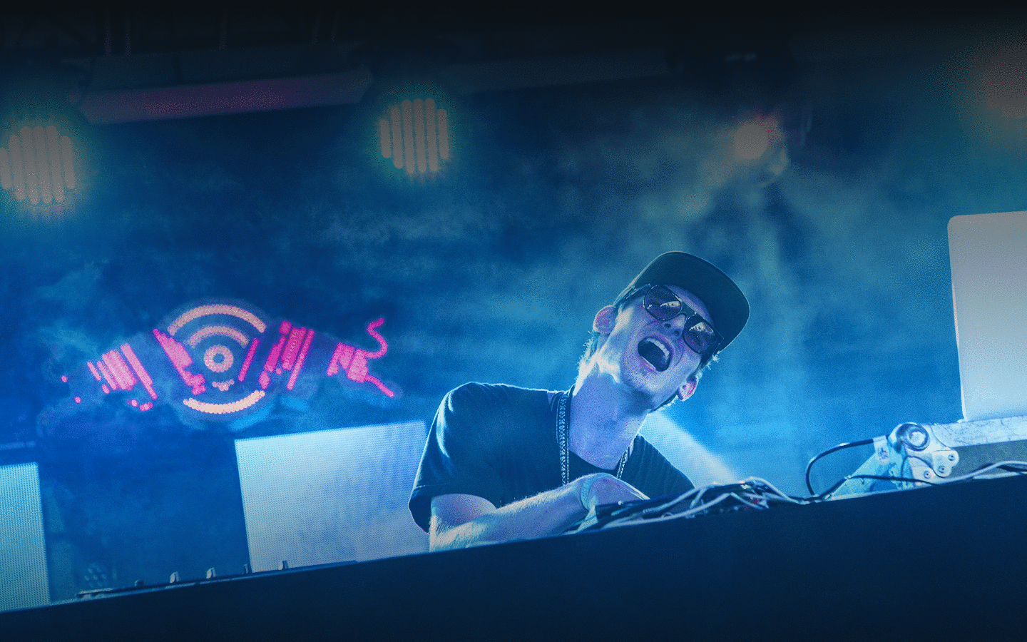 DJ performing under blue stage lighting at the Forecastle festival main stage