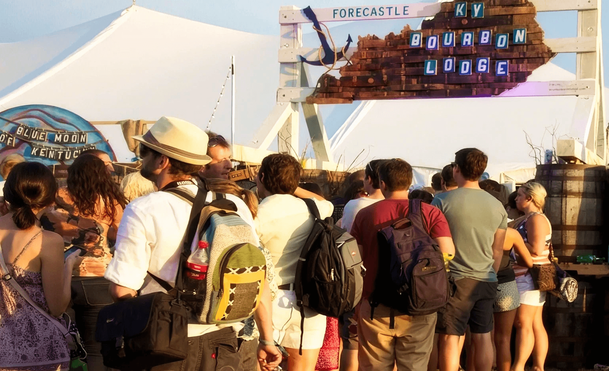 Crowd gathered at the Forecastle KY Bourbon Lodge branded tent at golden hour