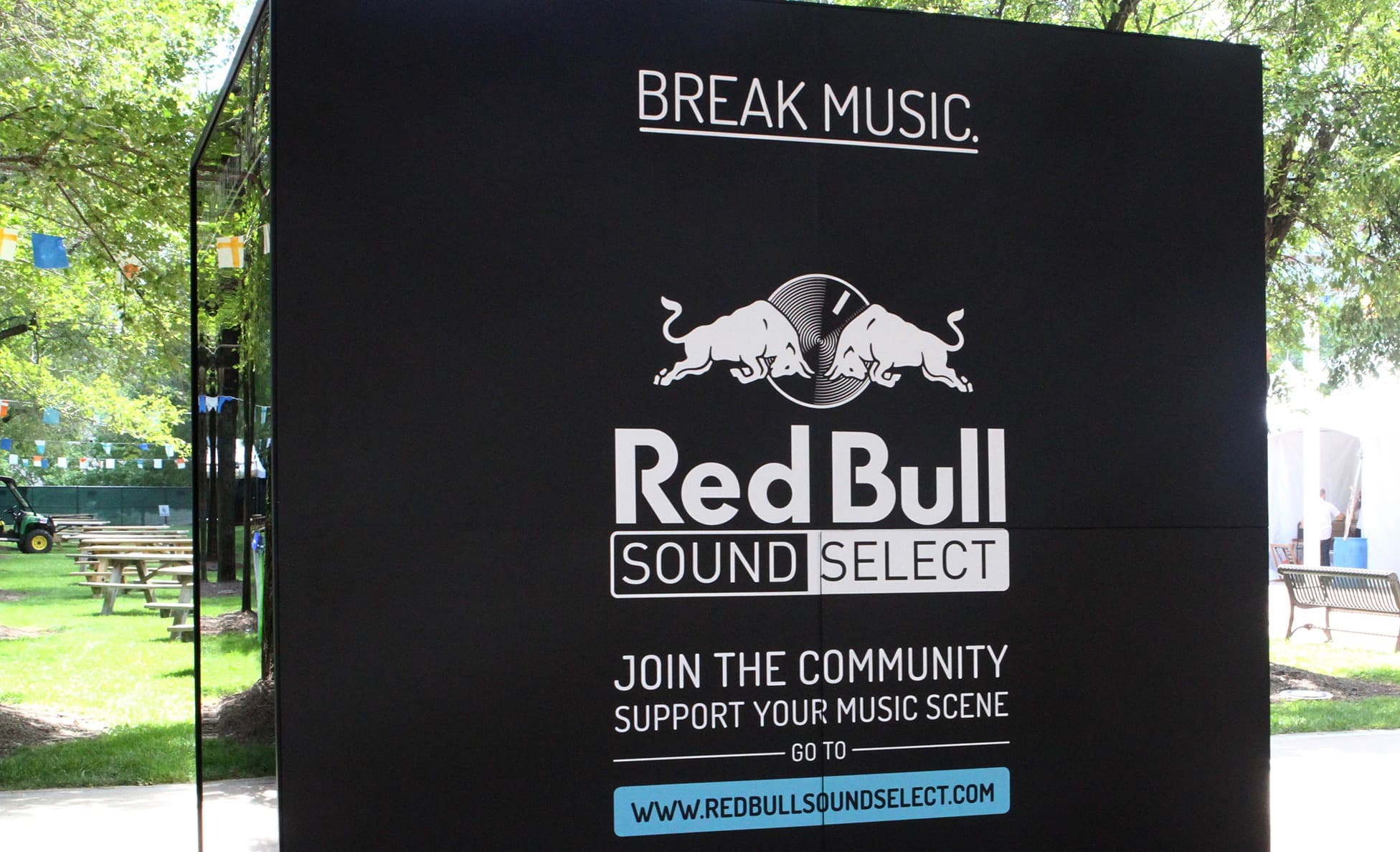 Red Bull Sound Select Break Music branded wall in a tree-lined festival park