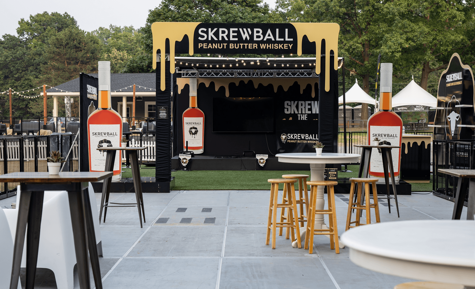 Skrewball Peanut Butter Whiskey branded stage lounge with oversized bottles and cocktail tables