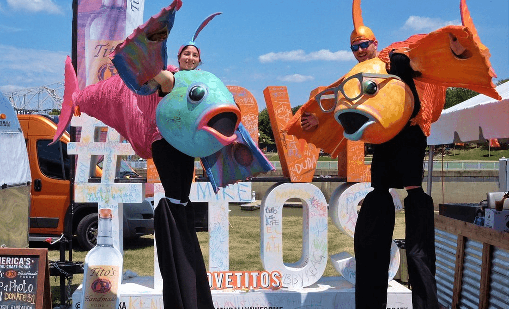 Two stilt walkers in colorful fish costumes at a Tito's Handmade Vodka activation
